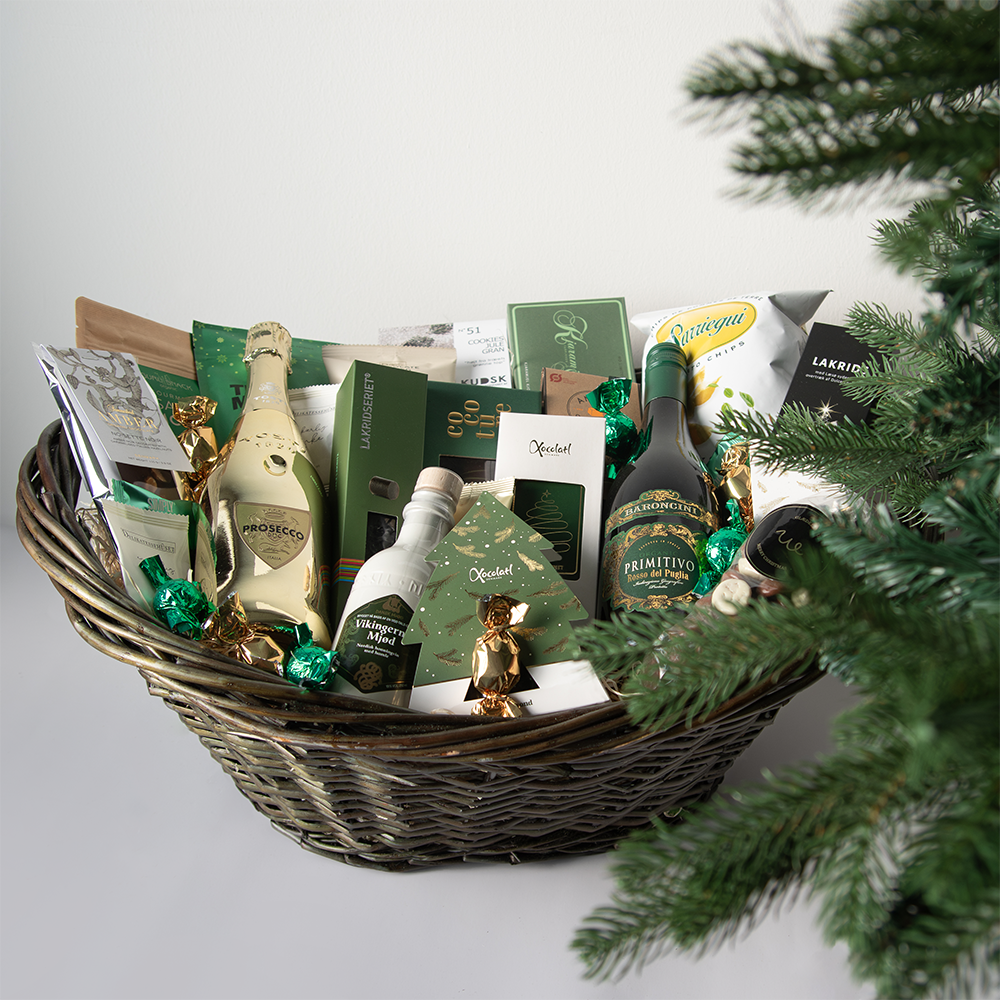 Stor julekurv med eksklusive delikatesser, chokolade, lakrids og julespecialiteter, smukt anrettet i fletkurv med cellofan og gavebånd