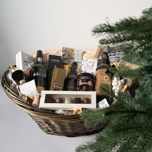 Kæmpe luksus gavekurv med vin, lakrids, chokolade og delikatesser, smukt anrettet i en fletkurv med cellofan og gavebånd