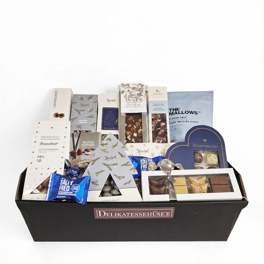 Blå julekurv med lækkerier i form af karameller, chokolade og skumfiduser