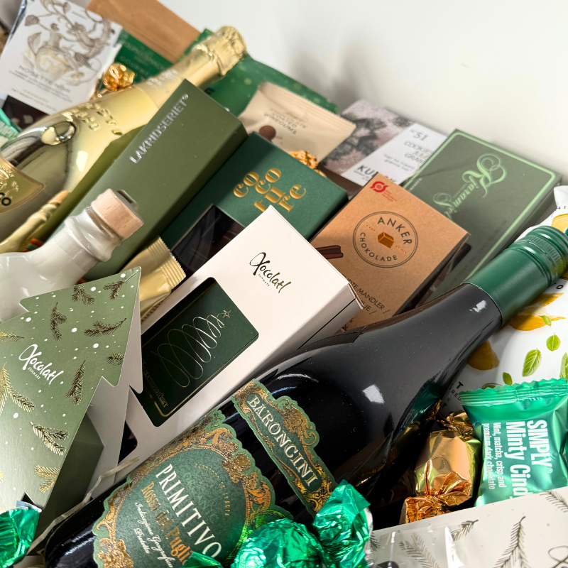 Stor julekurv med eksklusive delikatesser, chokolade, lakrids og julespecialiteter, smukt anrettet i fletkurv med cellofan og gavebånd