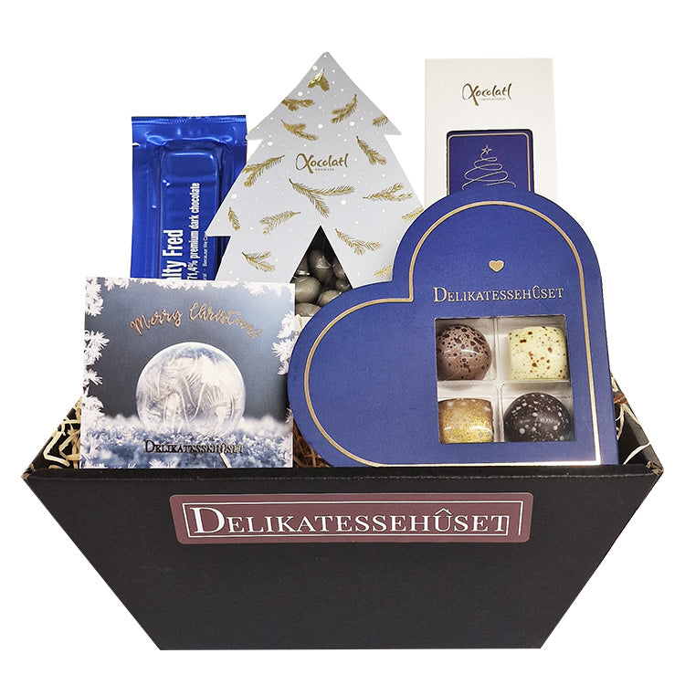 Smuk frostblå gavekurv med skønne julelækkerier og chokolade