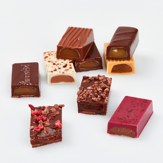 Udvalg af Summerbird tapas chokolade med marcipan, ganache og forskellige toppings på hvid baggrund.